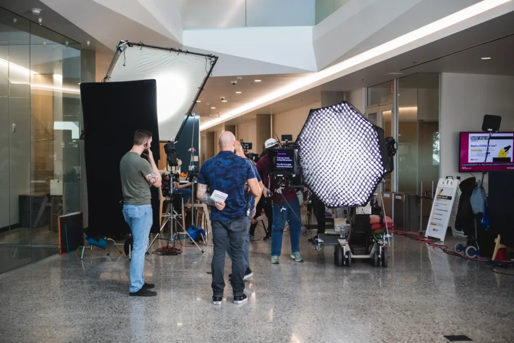 Pre-production crew setting up lighting and equipment for film shoot.