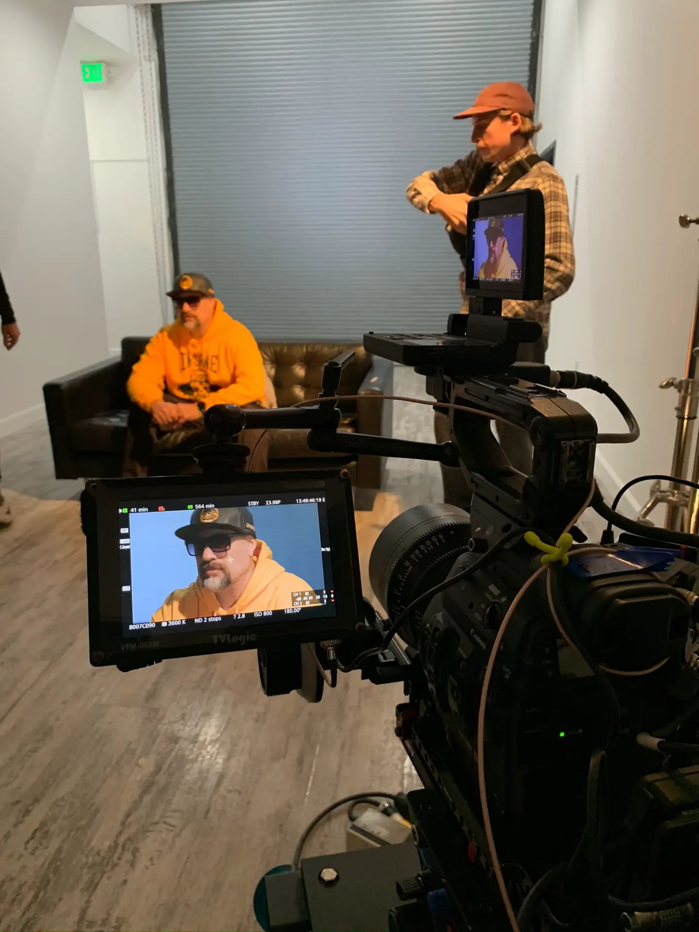 Camera crew filming people in a studio setup.