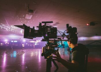 Cameraman filming indoors with professional cinema camera