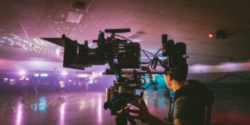 Cameraman filming indoors with professional cinema camera