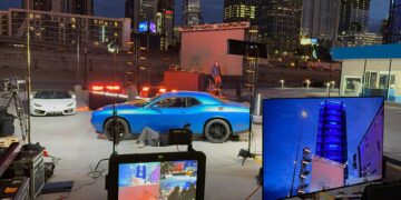Behind-the-scenes setup of a cityscape tv commercial shoot with lighting, screens, and camera gear.ht