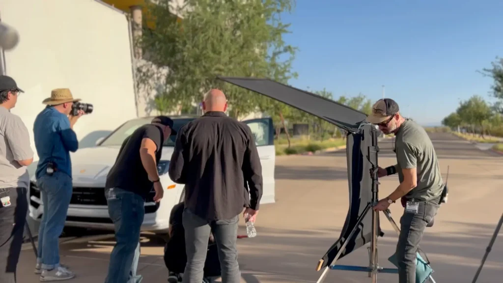 Film crew setting up outdoor car photoshoot