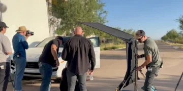 Film crew setting up outdoor car photoshoot
